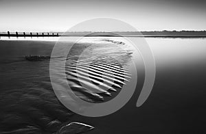 Beautiful low tide beach vibrant sunrise in black and white