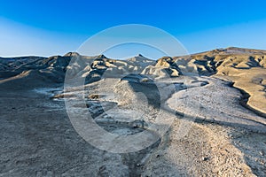 Beautiful lunar landscape with golden light at sunset over the muddy volcanoes