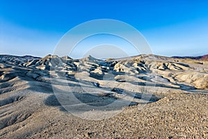 Beautiful lunar landscape with golden light at sunset over the muddy volcanoes