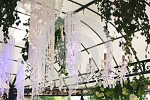 Beautiful luxurious romantic decor for a wedding celebration. The arch is decorated with draped fabric and a crystal