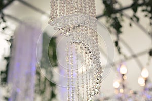 Beautiful luxurious romantic decor for a wedding celebration. The arch is decorated with draped fabric and a crystal