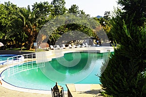 Beautiful luxurious swimming pool with crystal green waters in the garden