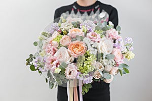 Beautiful luxury bouquet of mixed flowers in woman hand. the work of the florist at a flower shop. A small family