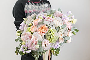 Beautiful luxury bouquet of mixed flowers in woman hand. the work of the florist at a flower shop. A small family