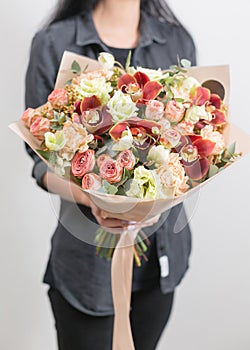 Beautiful luxury bouquet of mixed flowers in woman hand. the work of the florist at a flower shop. A small family