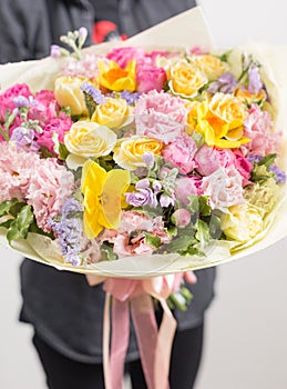 Beautiful luxury bouquet of mixed flowers in woman hand. the work of the florist at a flower shop. A small family