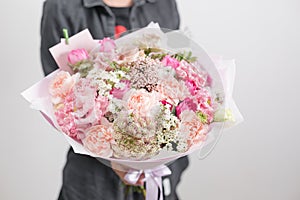 Beautiful luxury bouquet of mixed flowers in woman hand. the work of the florist at a flower shop. A small family