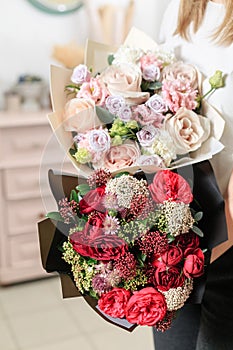 Beautiful luxury bouquet of mixed flowers in woman hand. the work of the florist at a flower shop. A small family
