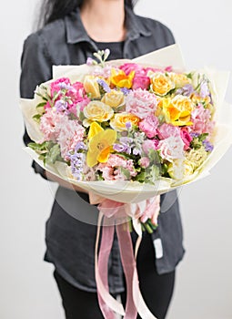 Beautiful luxury bouquet of mixed flowers in woman hand. the work of the florist at a flower shop. A small family