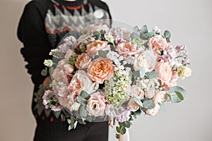 Beautiful luxury bouquet of mixed flowers in woman hand. the work of the florist at a flower shop. A small family