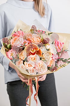 Beautiful luxury bouquet of mixed flowers in woman hand. the work of the florist at a flower shop. A small family