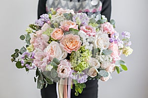 Beautiful luxury bouquet of mixed flowers in woman hand. the work of the florist at a flower shop. A small family