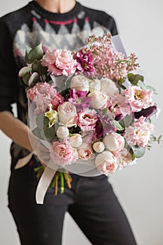 Beautiful luxury bouquet of mixed flowers in woman hand. the work of the florist at a flower shop. A small family