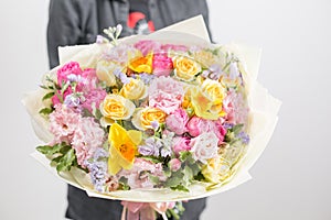 Beautiful luxury bouquet of mixed flowers in woman hand. the work of the florist at a flower shop. A small family