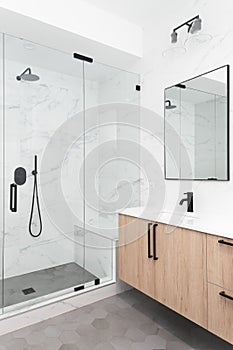 A wooden vanity with a large, marble tile shower.