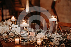 Beautiful luxury rustic wedding guest table decor - wooden tables with glass jars and candles, white roses and eucayptus leaves