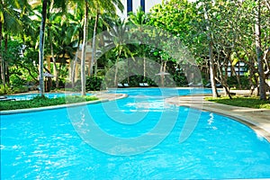 Beautiful luxury swimming pool with palm trees. Thai, Phuket. Vacation concept.