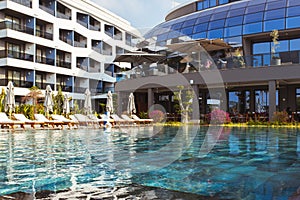 Beautiful luxury umbrella and chair around outdoor swimming pool in hotel and resort with coconut palm tree on blue sky