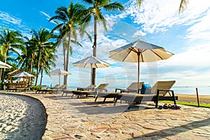 Beautiful luxury umbrella and chair around outdoor swimming pool in hotel and resort with coconut palm tree on sunset  or sunrise