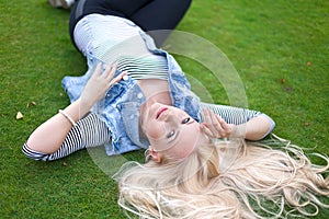 Beautiful lying on the green grass with untressed hair