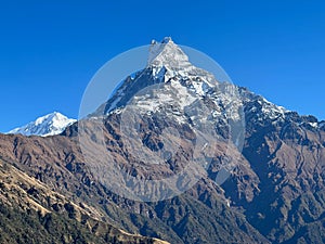 Beautiful Machapuchre Mountain with snowy peak in Nepal against the sunny blue sky