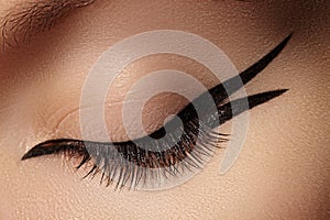 Beautiful Macro of Female Eye with Fashion Black Eyeliner Makeup. Perfect graphic Liner shape. Cosmetics and make-up