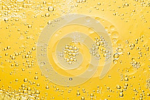 Beautiful macro photo of water droplets in oil with a yellow background. Abstract art