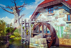 beautiful magic fairy water mill on blue sky background