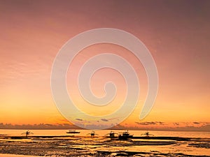 Beautiful, magical red sunset, sunrise in the tropics.Calm sea with dark silhouettes of boats. Low tide on beach