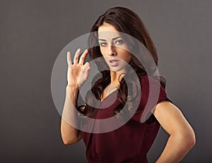 Beautiful makeup success serious business woman in red blouse showing ok cool sign by hand and looking concentrated. Closeup