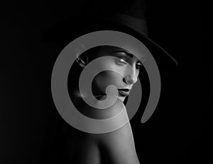 Beautiful makeup woman with elegant healthy neck, nude back and shoulder on black background in fashion hat with empty copy space