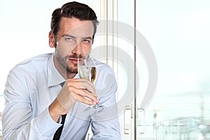 beautiful man drinking champagne with intriguing look and haughty