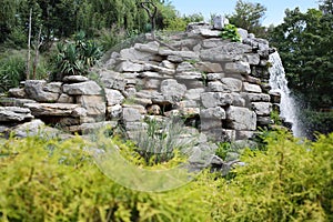 Beautiful man-made waterfall among rocks in summer