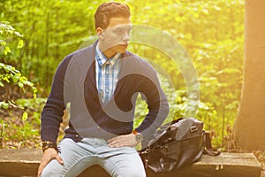 Beautiful man sitting on a bench. summer warm tone