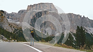 Beautiful man traveler walks along mountain roads in the Dolomites. Incredibly beautiful views in the Alpine mountains