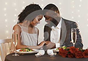 Beautiful man and woman in love cuddling during valentine dinner