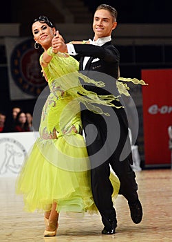 Beautiful man and woman perform smiling during dancesport competition