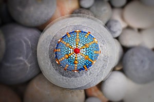 Beautiful mandala hand painted on a sea stone