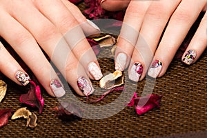 Beautiful manicure with flowers on female fingers. Nails design. Close-up