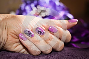 Beautiful manicure with a pattern of lilac