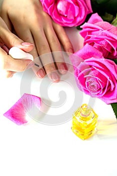 Beautiful manicured woman`s nails with pink polish and oil for cuticles isolated.