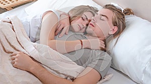 Beautiful married couple lies hugging in bed, life together, relationship in a pair