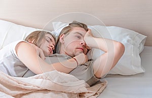 Beautiful married couple lies hugging in bed, life together, relationship in a pair