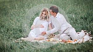 Beautiful married couple sitting on the grass during picnic