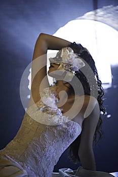 Beautiful masked woman in wedding dress