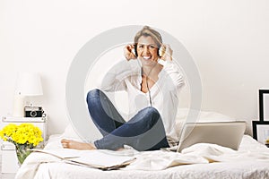 Beautiful mature business woman listening music with headphones. Break time.