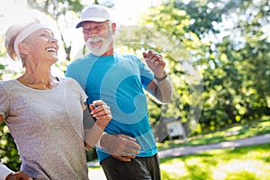 Beautiful mature couple jogging in nature living healthy