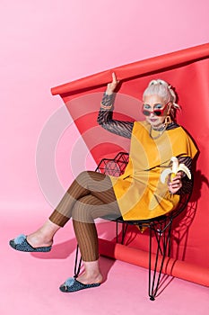 Beautiful mature female person having banana for lunch