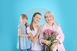 Beautiful mature lady, daughter and grandchild with flowers. Happy Women`s Day
