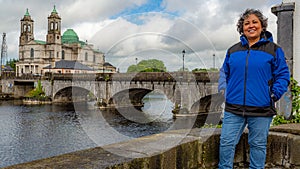 Beautiful mature mexican woman smiling with blue jacket in the city of Athlone in a beautiful spring day